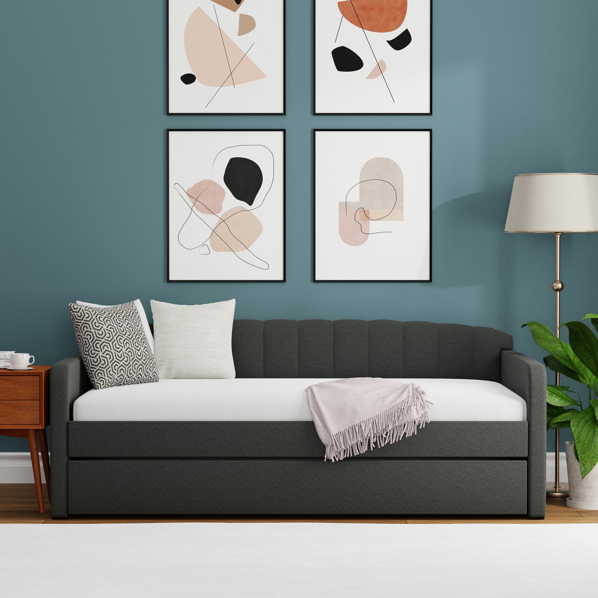 Gray sofa bed with white mattress in a room with abstract art on the wall.