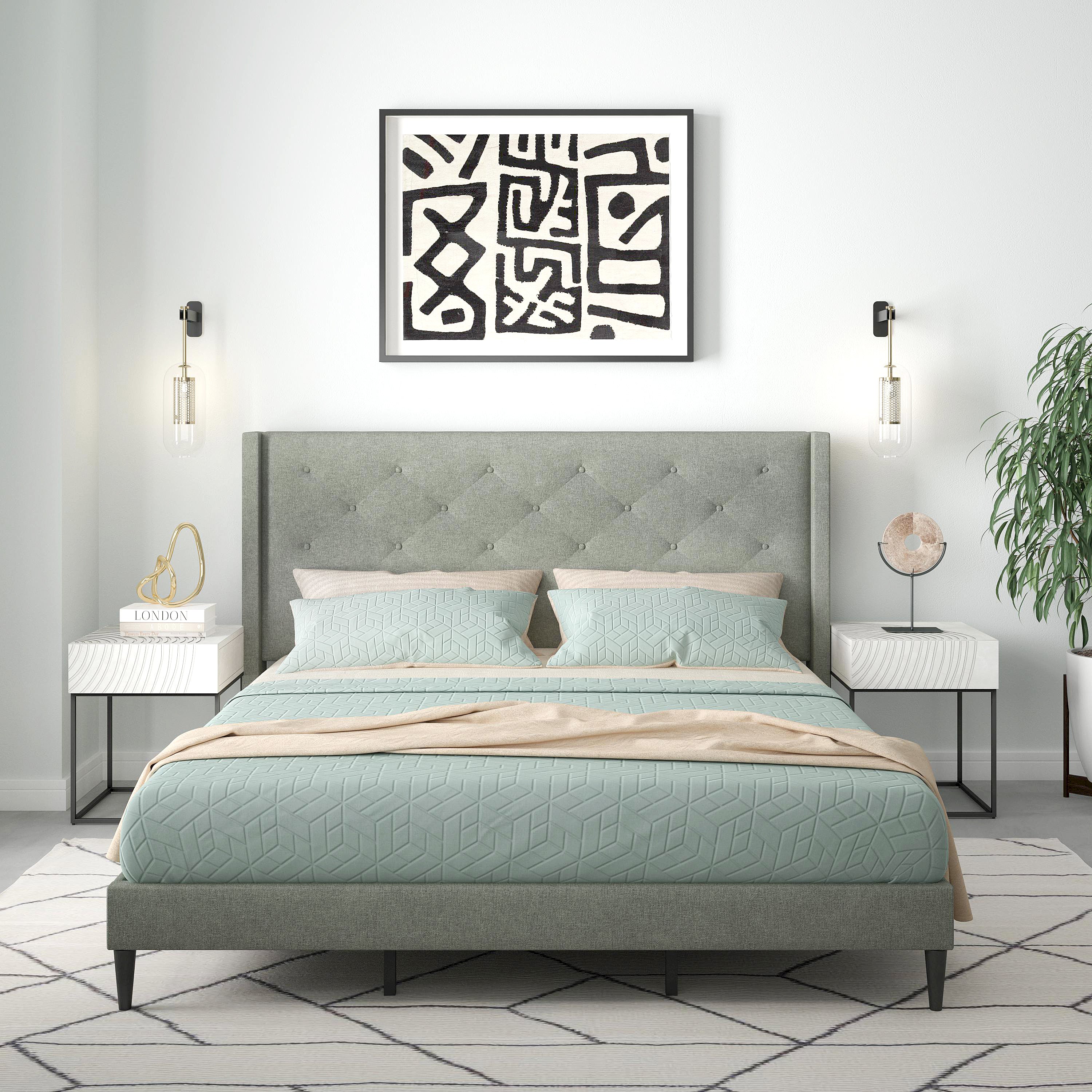 Modern bedroom with a gray upholstered bed, light blue bedding, and abstract wall art.